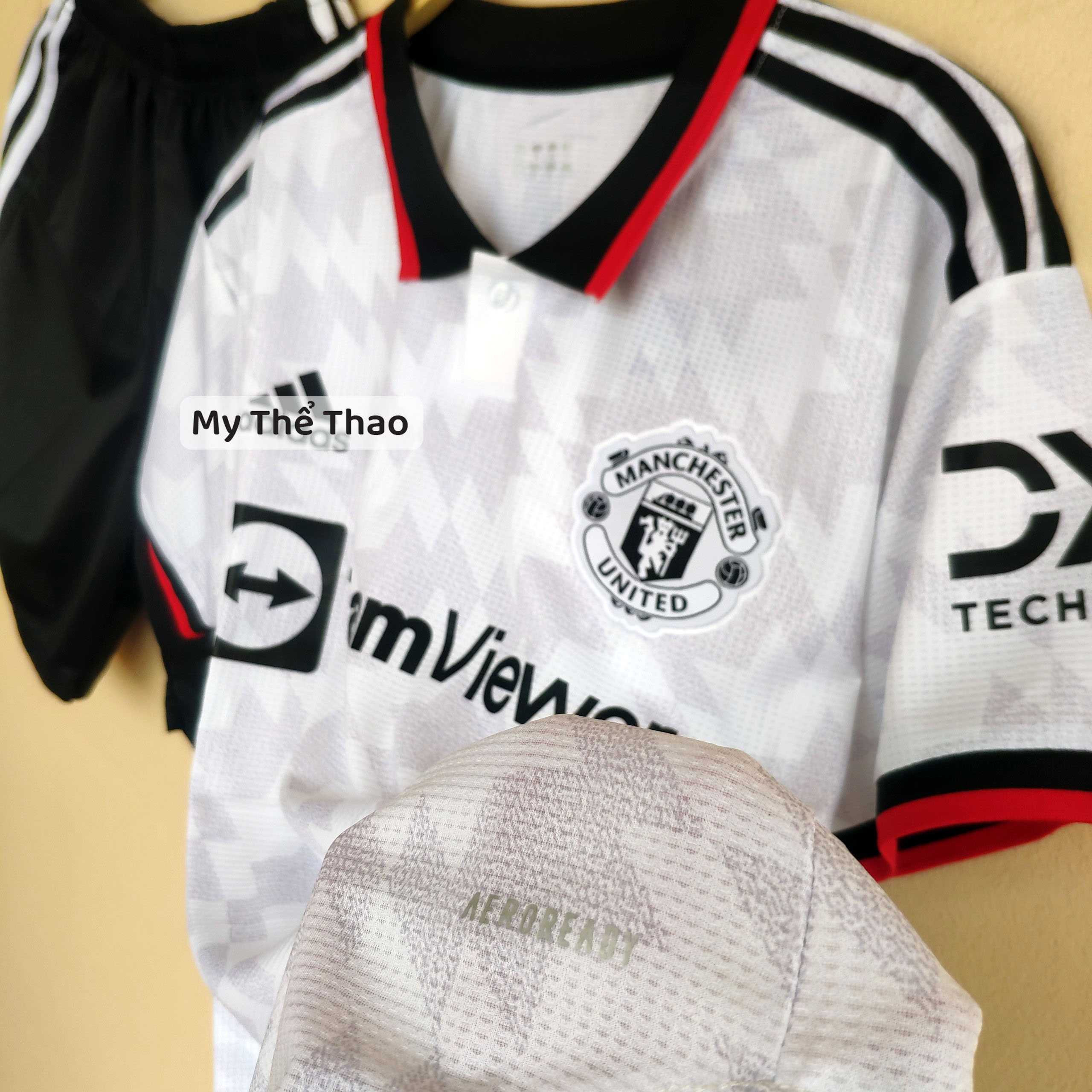 Bộ quần áo mu manchester united 2023 màu trắng xám có cổ bẻ màu đen logo thêu gai mịn thái 1
